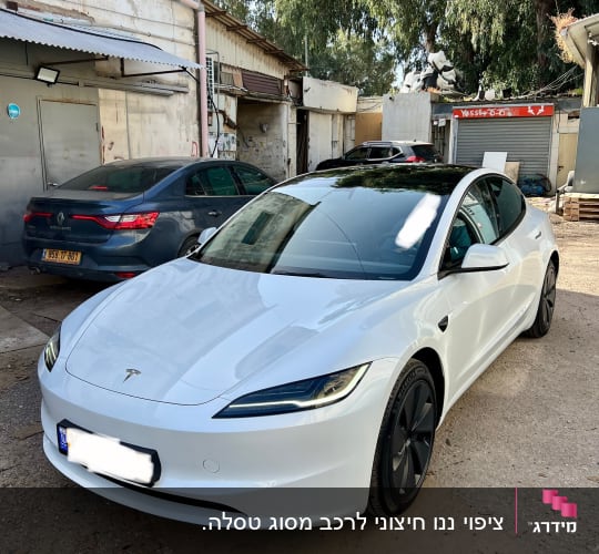 מכונית טסלה לבנה חונה בחניון פתוח
